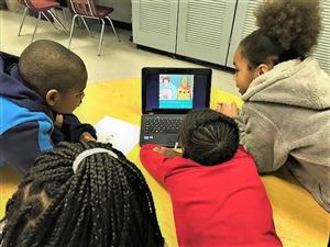 Four students working on a computer